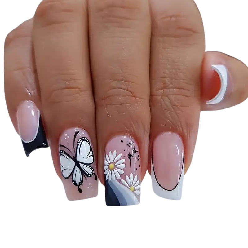 A hand displays Snazzi Nails Butterfly French Nails, featuring intricate butterfly designs with white daisies on two nails, while the rest sport a chic black and white French tip theme. The square-shaped nails are perfectly manicured.