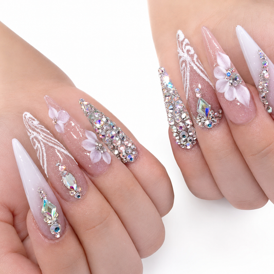 Hands wearing Crystal Petals light-pink extra-long stiletto press-on nails with white flowers, iridescent crystals and silver sparkle
