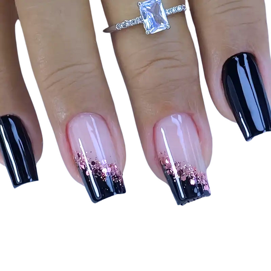 Black press on nails with pink glitter on hand 