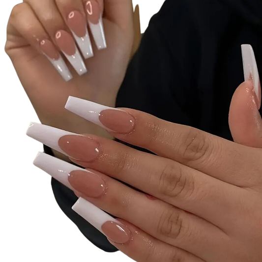 A set of extra long white and nude colored coffin-shaped false nails with a glossy finish, displayed on a hand.