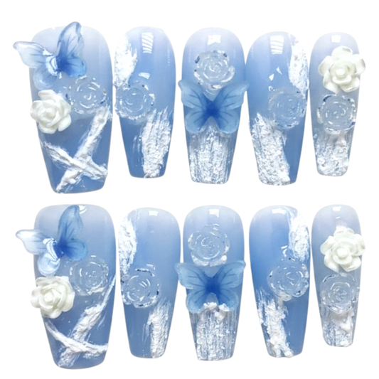 Snazzi Pink Shop long coffin press-on nails in powder blue with 3D butterflies, white roses, and floral art.