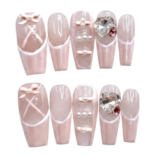 Snazzi Pink Shop Ballet Crush long coffin press-on nails with pearlescent pink finish, bows, pearls, and heart crystals.