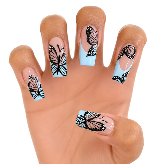 Snazzi Pink Shop extra-long coffin press-on nails with nude base, baby-blue French tips, and black butterfly art.