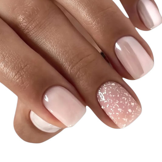 Snazzi Pink Shop Champagne Kiss short squoval press-on nails in blush pink with pearl chrome and glitter accents.