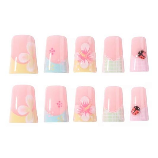 Snazzi Pink Shop Garden Picnic medium duckbill press-on nails with pastel floral patterns and ladybug accents.