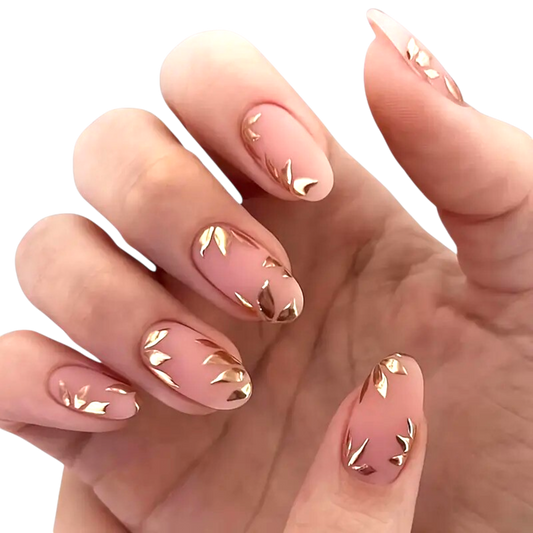 Snazzi Pink Shop Golden Leaves medium oval press-on nails with a matte nude base and metallic gold botanical accents.