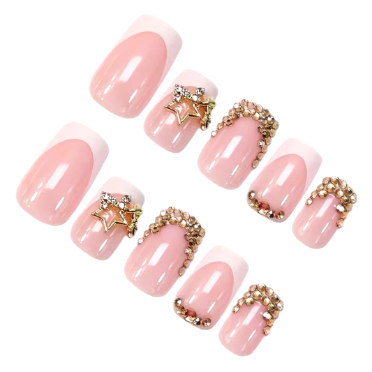 Snazzi Pink Shop medium square press-on nails with blush pink French tips, champagne crystals, and gold star charms.