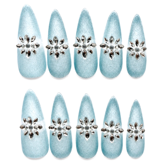 Snazzi Pink Shop Frozen Petals extra long stiletto nails in icy blue with frosted shimmer and rhinestone flowers.
