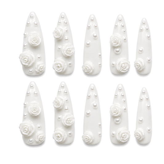 Snazzi Pink Shop extra long stiletto bridal nails in ivory with sculpted white roses and luminous pearl accents.