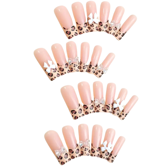 Snazzi Pink Shop extra long coffin press-on nails with leopard print tips and white bow accents in a glossy finish.