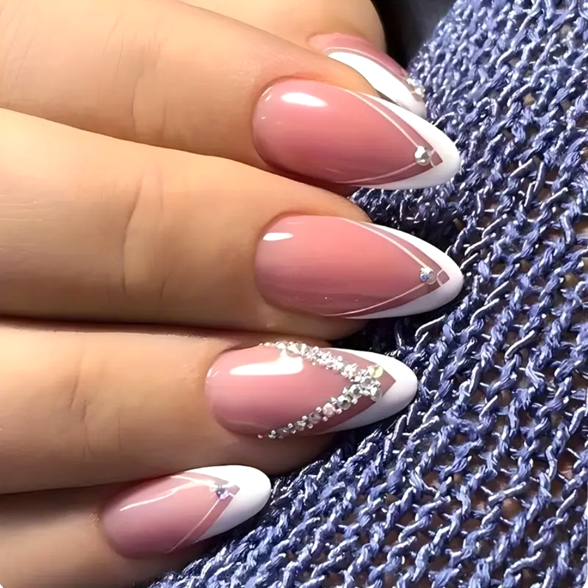 Snazzi Pink Shop long almond press-on nails with glossy pink base, white V-French tips, and rhinestone accents.
