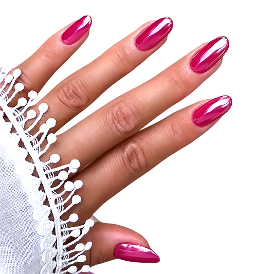 Snazzi Pink Shop long oval press-on nails in a vibrant glossy magenta finish on a hand with white lace sleeve