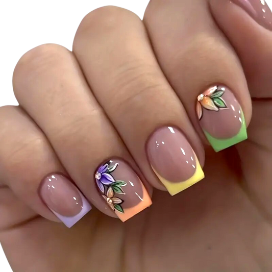 Snazzi Pink Shop short square press-on nails with pastel rainbow French tips and delicate floral accent artwork.
