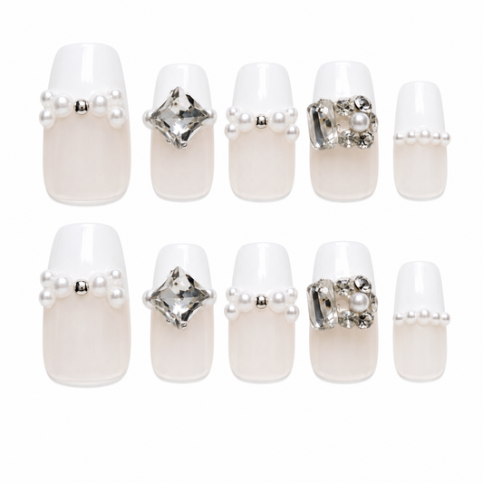 Snazzi Pink Shop Pearl Poise medium coffin press-on nails with white French tips, pearls, and oversized crystals.