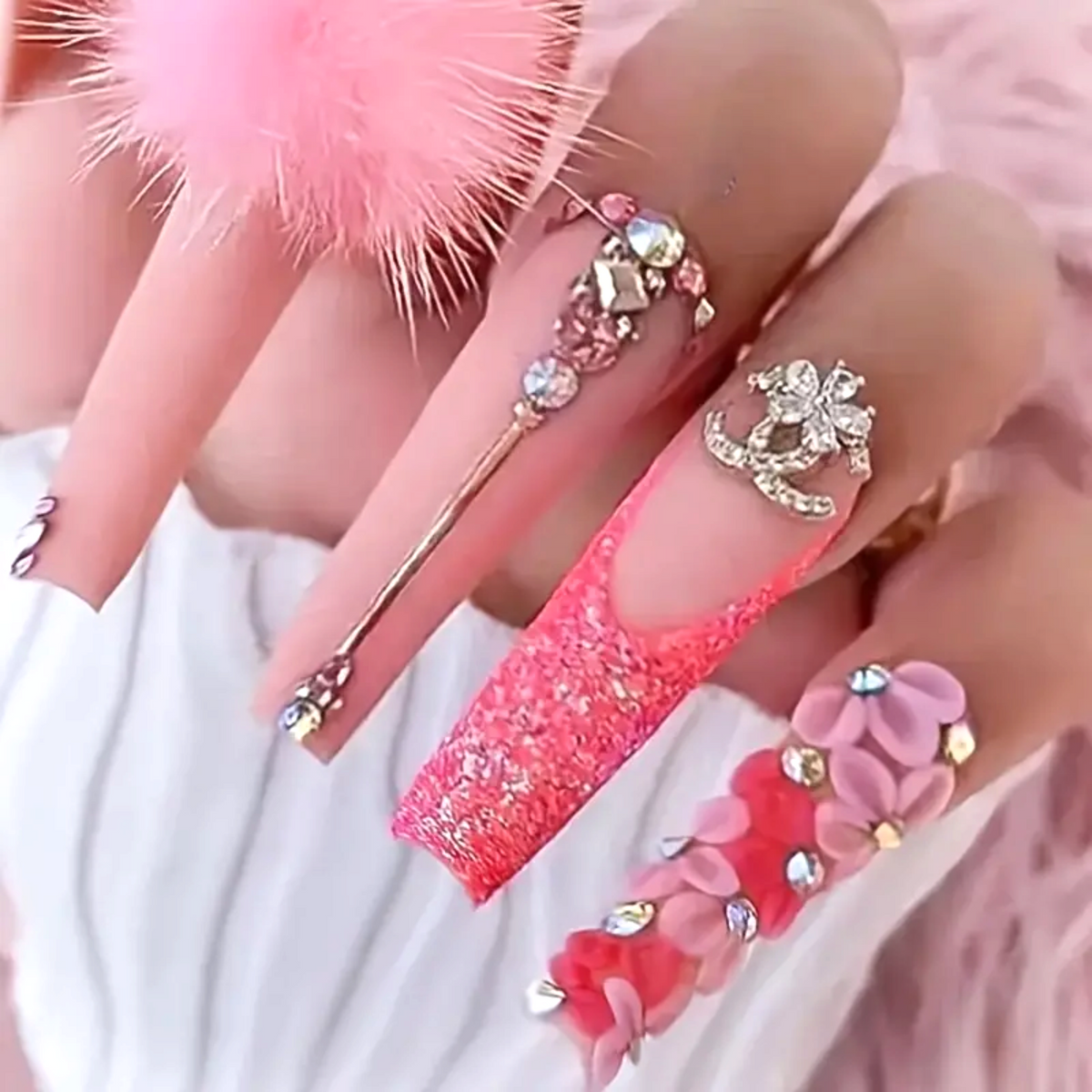 Snazzi Pink Shop extra long coffin press-on nails with pink pom pom, 3D floral details, and rhinestone accents.