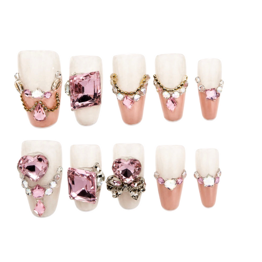 Snazzi Pink Shop Pink Heiress long coffin press-on nails with pink hearts, square crystals, gold chains, and bows.