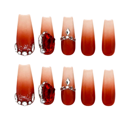 Snazzi Pink Shop Ruby Eclipse extra long coffin nails with nude to deep red ombre, red gems, and silver accents.