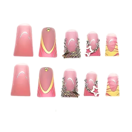 Snazzi Pink Shop Starburst Swirl long duckbill press-on nails with pink ombre, gold curves, crystals, and star charms.